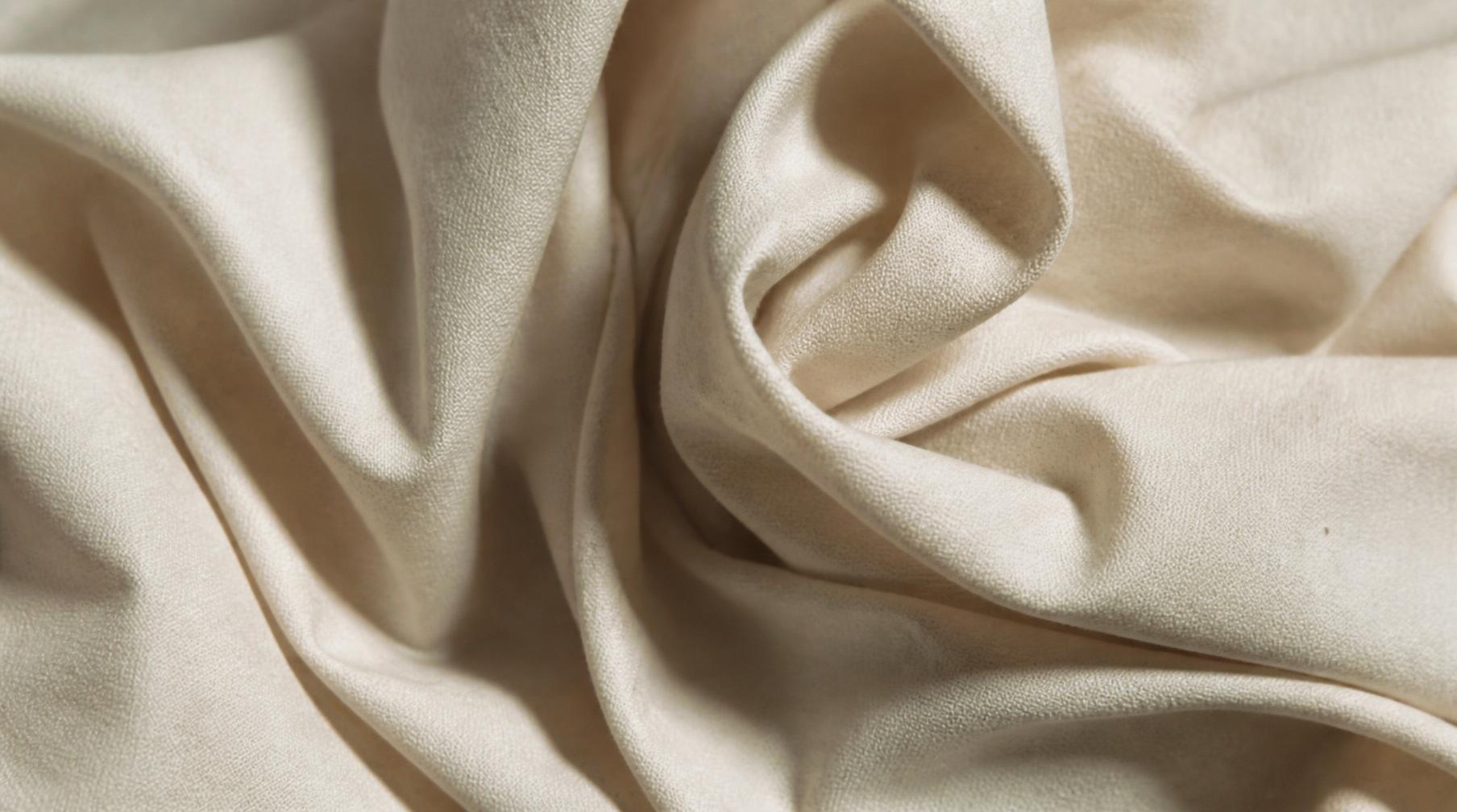 Close detail of folded raw natural cloth in bone white
