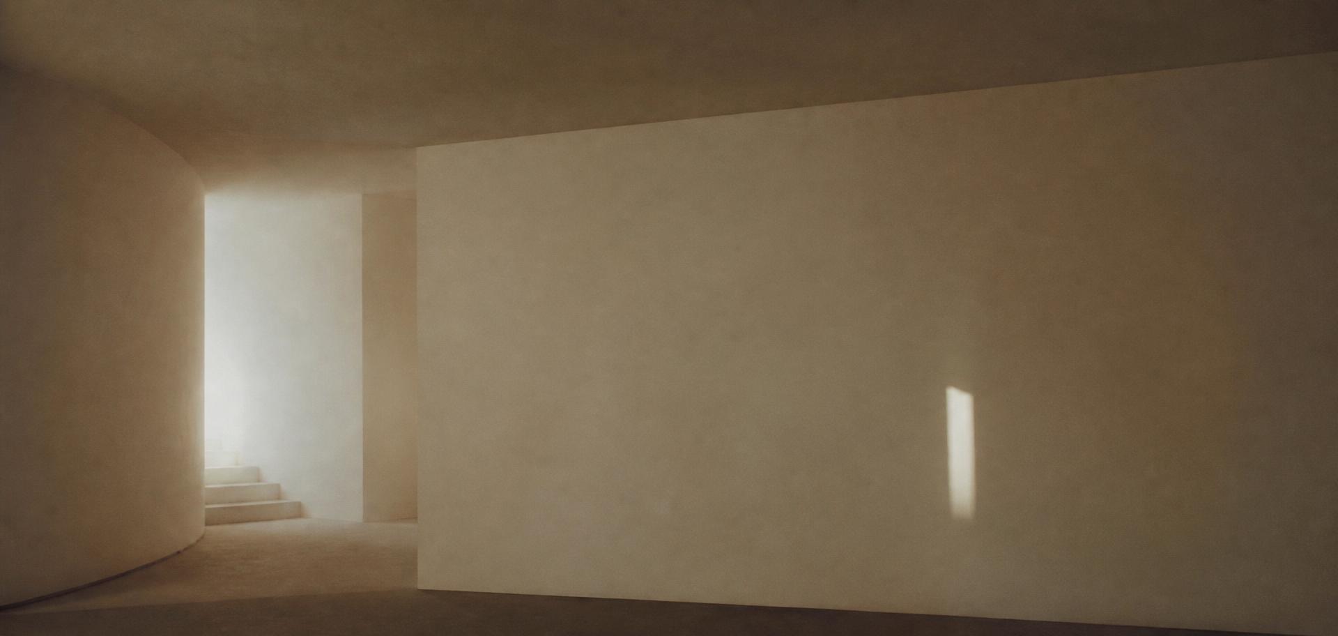 An empty pale interior with a single shaft of light on a bare wall